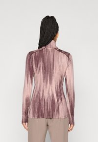 Dugi rukav s visokom ovratnikom u nijansama ružičaste i mauve, s teksturiranim, linearnih uzorkom i prilagođenim siluetom.