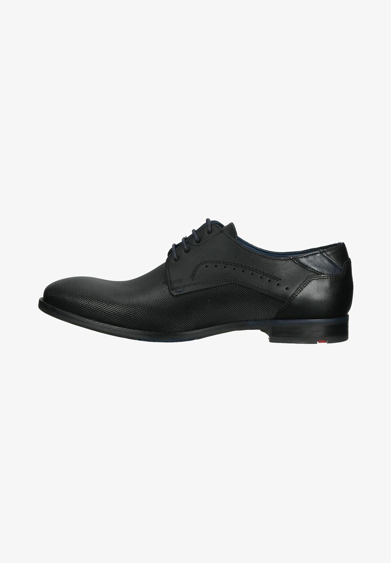 Black leather dress shoe with a textured surface, rounded toe, and subtle perforated details. Features a slim, flat sole and minimal stitching accents.