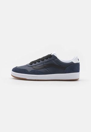 Navy blue sneaker with a mix of leather and suede, featuring black laces, white accents, and a gum rubber sole. Low-profile design.