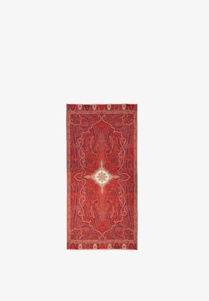 Tapis rectangulaire rouge avec des motifs cachemire et floraux complexes, présentant un design symétrique et un médaillon central blanc en forme de losange.