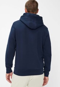 Marineblå sweatshirt med hætte, lavet af blødt stof. Har en kængurulomme og ribbede mansjetter. Enkel, minimalisk design.