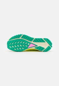 Semelle d'une chaussure de sport avec une bande de roulement verte, une semelle intermédiaire beige et un détail triangulaire rose au centre sur un fond blanc uni.