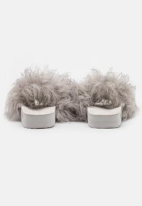Furry grey slide sandals with a platform sole and rounded footbed. Material appears soft with a textured, fluffy design.