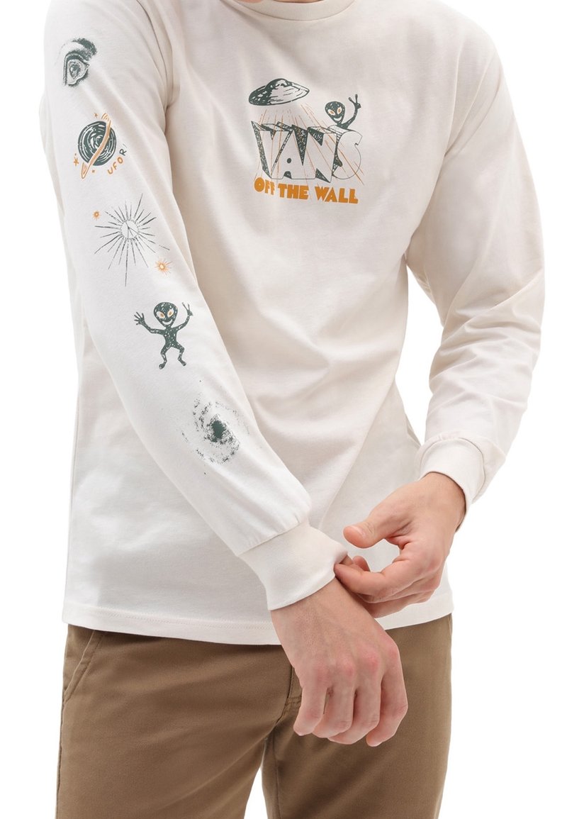 Kremowa koszula z długim rękawem ozdobiona nadrukami przedstawiającymi kosmitów, planety i gwiazdy. Wykończenie mankietów prążkowaną dzianiną i luźny fason.