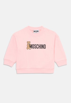 Pink baby sweatshirt with a teddy bear graphic holding the "Moschino" logo in black letters on the front, ribbed cuffs, and snap buttons on the shoulder.