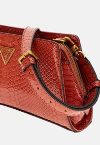 Borsa a tracolla rossa in finta pelle di serpente con chiusura a doppia zip, hardware dorato e manico corto con fori regolabili.