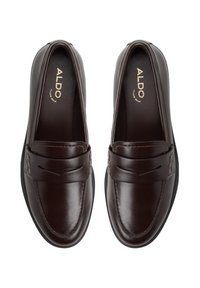 Bruine leren instappers met een gladde afwerking, voorzien van een gestikt ontwerp en een decoratieve band over de wreef. Zwarte rubberen buitenzool.