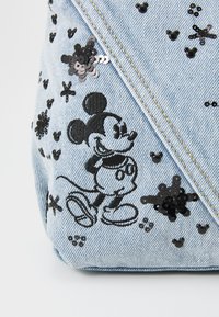 Borsa in denim con design ricamato di Mickey Mouse nero. Decorata con paillettes e perline, nei toni di blu e nero, con texture a disegni.