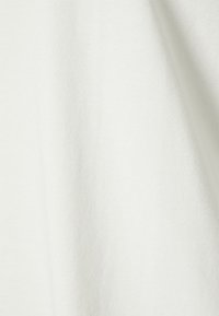 Tecido leve e macio de algodão em off-white, com uma textura suave e um ligeiro brilho; apresenta um detalhe de costura subtil ao longo das bordas.