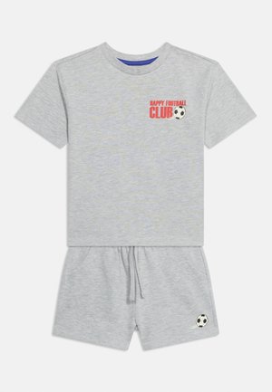 Conjunto gris claro de camiseta de manga corta y pantalones cortos con texto rojo "Happy Football Club" y gráficos de balón de fútbol en la camiseta y los pantalones cortos.