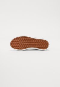 Suola di scarpa in gomma con un motivo a nido d'ape, presenta una base marrone e bordi bianchi. Design piatto con una superficie testurizzata per una migliore aderenza.