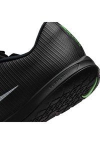 Μαύρο αθλητικό παπούτσι Nike με υφή στο επάνω μέρος, σόλα "Pulsion", πράσινες λεπτομέρειες και μερικά ορατά "Mercurial" γράμματα στο πίσω μέρος.