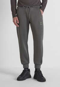 Grijze joggingsbroeken met een slim fit, gemaakt van zacht materiaal, met elastische manchetten, zijzakken en een klein logo-embleem.