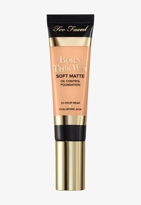 Soft matte foundation in a beige tube with a black cap. Gold accents and lettering. Claims 24-hour wear and contains hyaluronic acid.