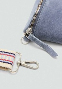 Borsetta in suede blu con zip argentata, caratterizzata da una superficie texturizzata e una tracolla in tessuto con strisce multicolori e un attacco in metallo.