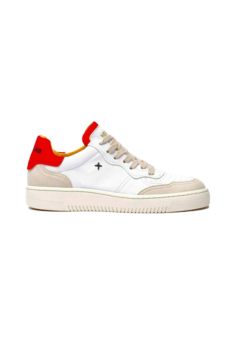 Zapatilla blanca con acentos rojos y amarillos, detalles en gamuza beige, suela de goma texturizada y diseño de cordones en la parte frontal.