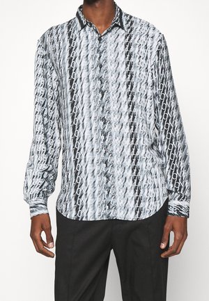 Camicia a maniche lunghe con bottoni, caratterizzata da un motivo astratto bianco e nero con design di testo ripetuto e colletto standard. Tessuto morbido al tatto.