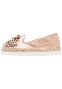Espadrillas rosa dorato con tomaia in tessuto testurizzato, decorazioni floreali e suola avvolta in juta; presenta un fondo in gomma bianca.