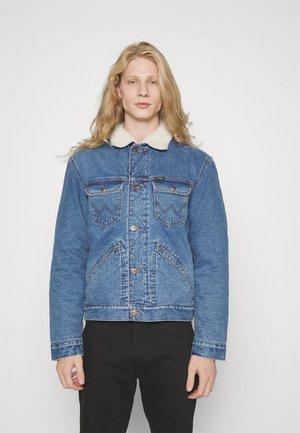 Denim jacket in medium blue with a shearling collar, large chest pockets, contrasting stitching, and button-up front. صافứa