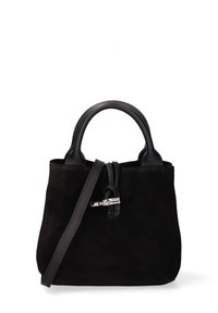 Zwarte suède handtas met ronde leren handvatten, een zilveren sluiting aan de voorkant en een lange schouderriem op een witte achtergrond.