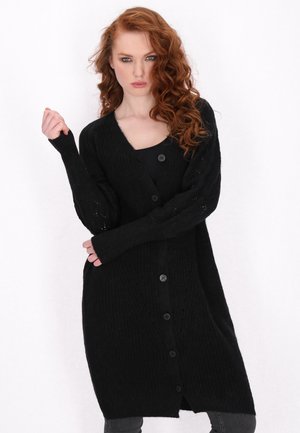 Schwarze lange Strickjacke mit gerippter Textur, V-Ausschnitt und Knopfverschluss vorne. Mit langen Ärmeln und lockerer Passform.
