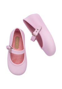 Bailarinas de goma rosa con punta redondeada, aberturas elásticas y una pequeña correa con una hebilla plateada. Forro interior rosa suave.