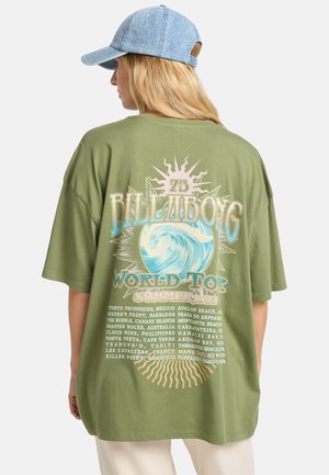 Olivgrünes, übergroßes T-Shirt mit buntem Grafikdruck, der eine Welle, die Sonne und einen Text mit verschiedenen Strandstandorten zeigt.