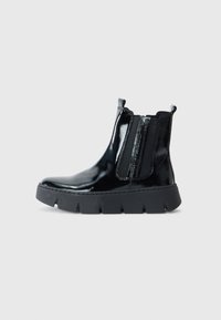 Bottines en cuir verni noir avec des panneaux élastiques sur les côtés et une épaisse semelle noire, présentant une finition lisse et brillante ainsi qu'un design minimaliste.