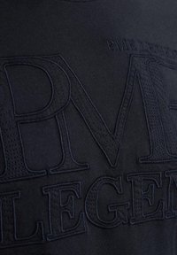 Laivastonsininen collegepaita, jossa on kimmoisa kohopainatus ja edessä selvästi näkyvissä kirjaimet "PME LEGEND".