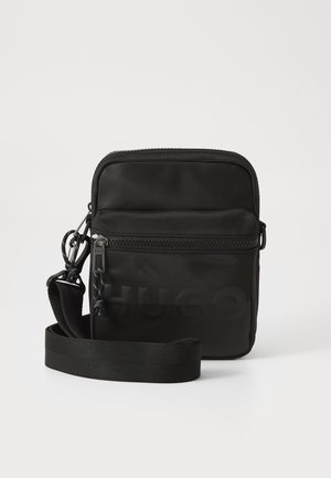 Geantă crossbody din nylon negru, cu închidere cu fermoar, curea ajustabilă și logo-ul „HUGO” embosat pe față. Textură netedă, formă rectangulară.