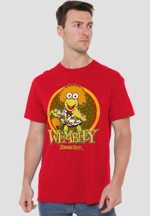 Man wearing red t-shirt with a colorful graphic of Wembley from Fraggle Rock and bold text "Wembley" on front.