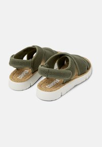 Green mesh sandals with a cork insole and white rubber outsole, featuring cross straps and a cushioned back for comfort.