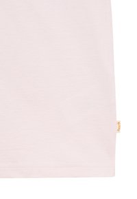 Tissu rose clair avec une petite étiquette beige portant la mention "Blkvis" cousue dans la couture en bas à droite.