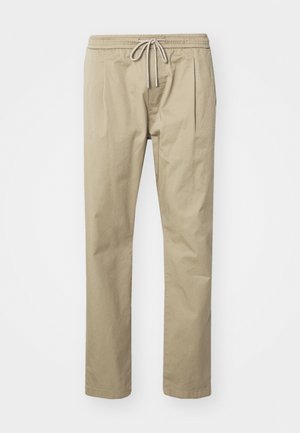 Beige chinos made of cotton blend, featuring an elastic waistband with a drawstring, and side pleats for added comfort and style.