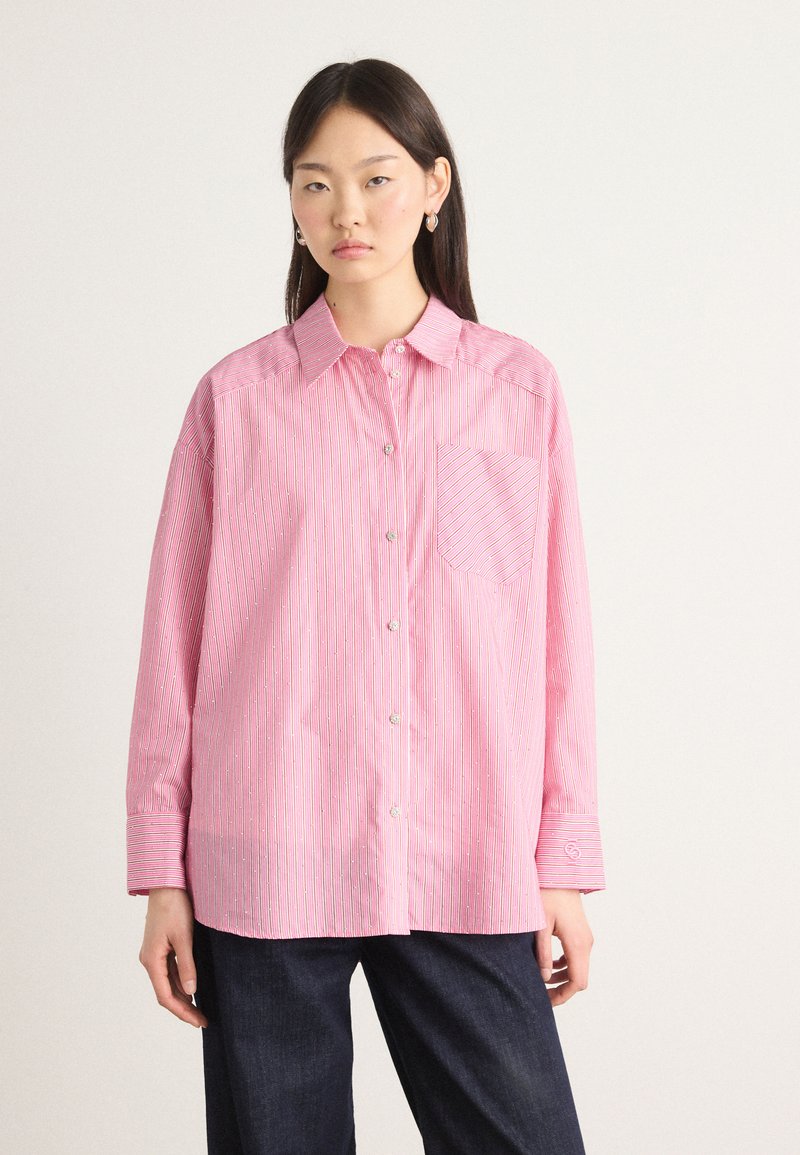 Pink striped button-up shirt featuring a chest pocket, long sleeves, and buttons with a smooth texture. Accents include subtle detailing.