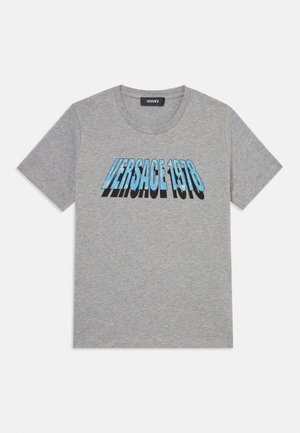 Sivé tričko s krátkym rukávom s modrým textom "VERSACE 1978" a čiernym tieňovaním na hrudi, s okrúhlym výstrihom.