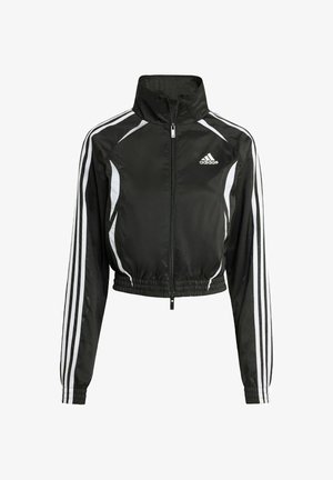 Veste noire courte en matériau léger, dotée d'un col haut, d'une fermeture éclair sur toute la longueur, de bandes blanches sur les côtés et d'un logo brodé sur la poitrine.