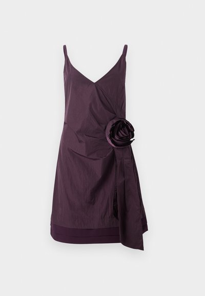 Purple sleeveless dress with a v-neck, featuring crinkled texture and a large fabric rose accent on the left side. Wrapping design detail at the waist.