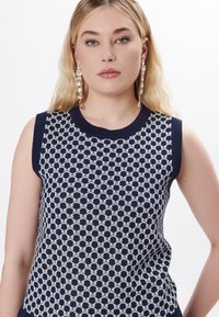 Top senza maniche in maglia con un motivo a esagoni blu navy e bianco, scollatura rotonda e finitura testurizzata.