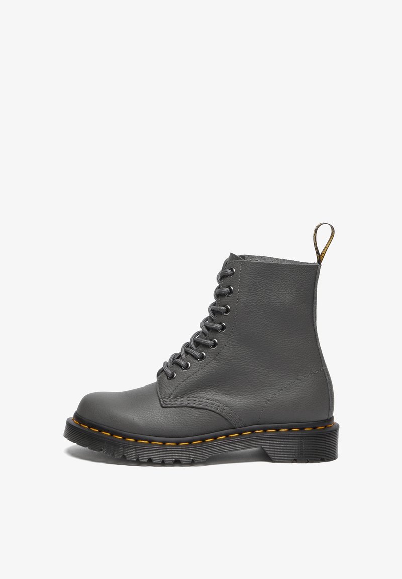 Botte en cuir gris à lacets avec des coutures jaunes, une semelle épaisse à rainures marquées et une languette d'extraction à l'arrière.