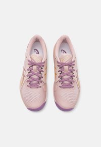 Lyserøde sneakers med lilla detaljer og snørebånd. Mesh-struktur på siderne, gummisål og guldbranding på tungen.