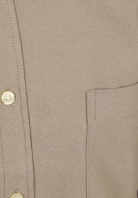 Beige overhemd met een gestructureerde stof, een puntige kraag, drie knopen en een borstzak, met een strak en eenvoudig ontwerp.