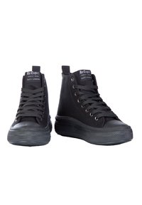Czarne sneakersy za kostkę wykonane z płótna, z gumowymi podeszwami, charakteryzujące się sznurowanym zapięciem, teksturowaną powierzchnią i metkami marki na języku.