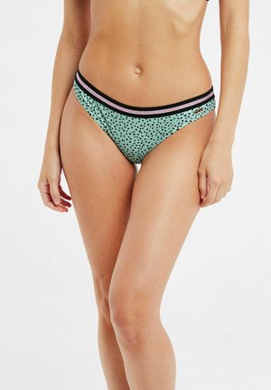 Bas de bikini vert menthe avec ceinture élastique noire et rose, présentant un motif à pois ludique, confectionné en tissu doux et extensible.