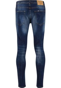 Tmavě modré džínové kalhoty s úzkým střihem. Mají středně vysoký pas, dvě zadní kapsy a jemně vybledlé detaily.