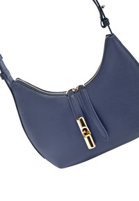 Borsa a spalla in pelle blu con texture, dettagli in oro per la zip e il lucchetto, tracolla regolabile e bordo superiore curvo.