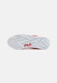 Fila sneaker outsole in white rubber with zigzag tread pattern. Features red accents and logo at the heel. Smooth texture, durable design.