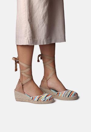 Wedge espadrilles with multicolored striped fabric, beige ankle ties, and woven jute soles. Smooth texture and open sides for breathability.