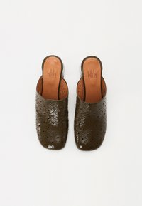 Mules en cuir perforé vert foncé avec une finition lisse et un bout arrondi. Les semelles intérieures sont en cuir tan avec des détails de logo embossés.