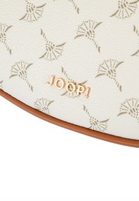 Borsa in materiale bianco testurizzato con motivo a foglie ripetuto in marrone chiaro, con logo "JOOP!" dorato nella parte inferiore. Rifinitura marrone lungo il bordo.